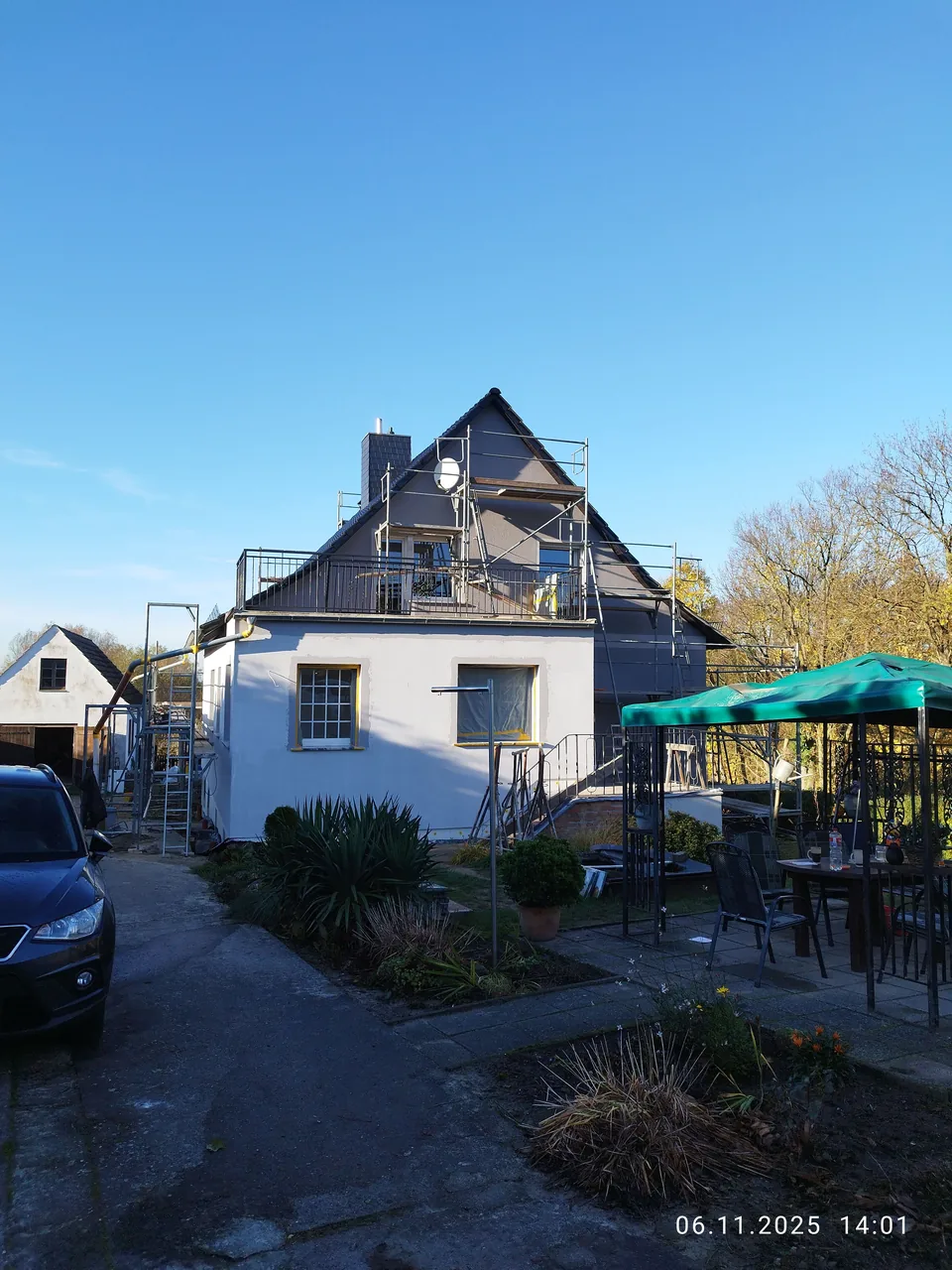 Wohnhaus mit Baugerüst an der Giebelseite unter blauem Himmel