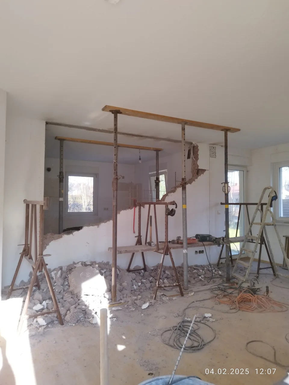 Innenraum während des Rückbaus einer Wand mit Baustützen und Bauschutt